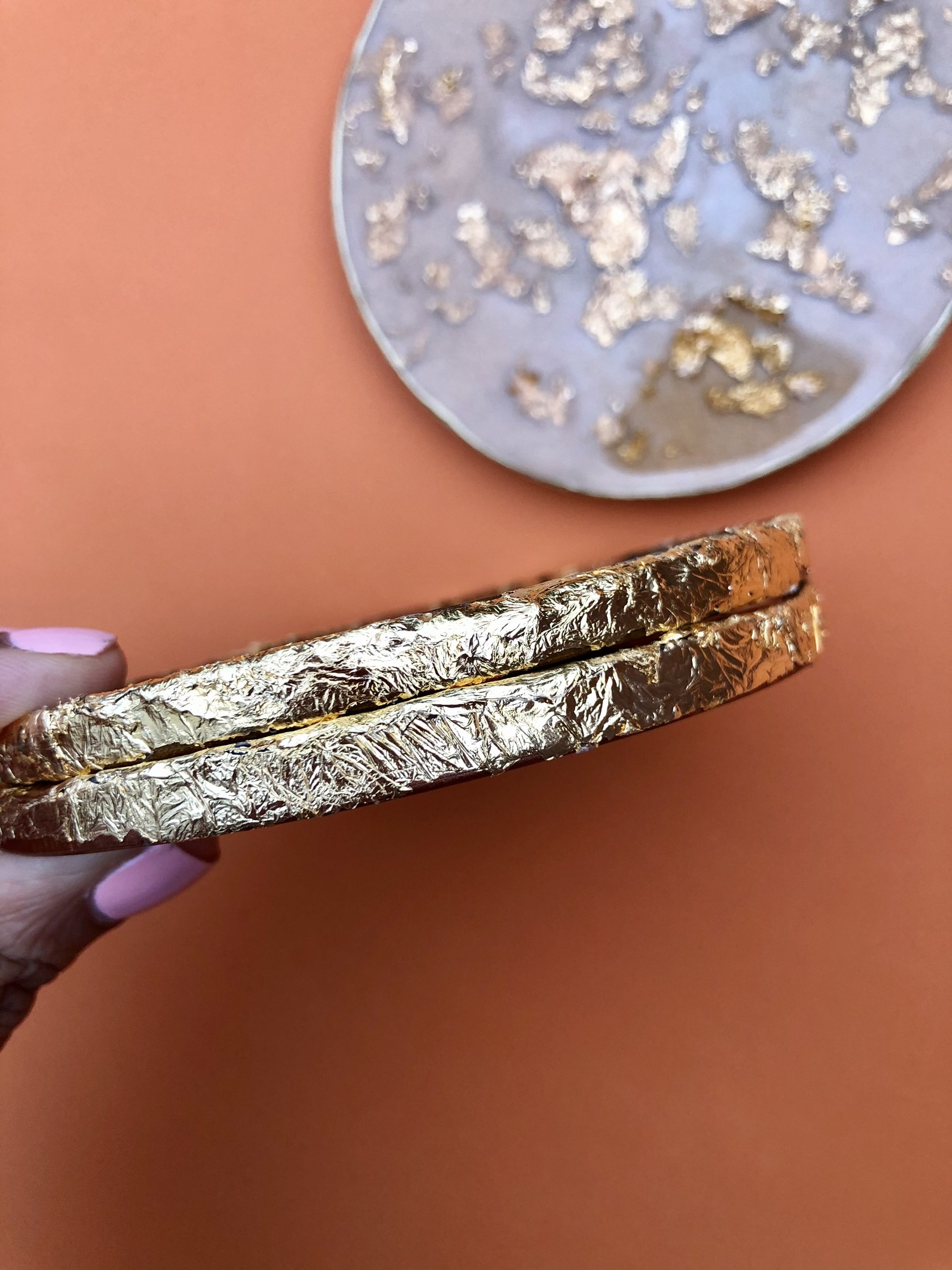 Detail shot of the gold-leaf textured edge on OhGosh.Gallery coasters